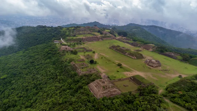 Vista aérea de la Gran Plaza de Monte Albán sobre la montaña, con la ciudad de Oaxaca al fondo